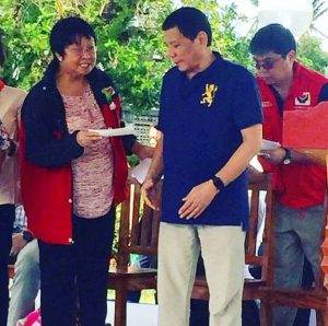 DSWD Sec.Judy M. Taguiwalo shows a check to Pres. Rodrigo Duterte during the ceremonial turn over of checks to beneficiaries of Emergency Shelter Assistance (ESA) in Batanes yesterday while DSWD Disaster Emergency Response Management Bureau (DREaMB) Director Felino O. Castro V looks on. 