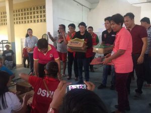 Department of Social Welfare and Development (DSWD) Secretary Judy Taguiwalo (4th from left) and Tuguegarao City Mayor Jefferson Soriano (5th from left) distribute food packs to the displaced families staying inside the Tuguegarao People’s Gym to show that an efficient disaster relief operations need the joint effort of the National Government and the Local Government Units.