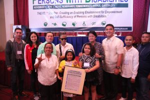 DSWD Secretary Judy Taguiwalo (4th from right) and Assistant Secretary Anton Hernandez (3rd from right) beam as they pose with some PWD-participants of the national summit during the symbolic turn over of the PWD 10-Point Development Agenda.