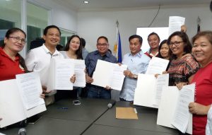 DSWD Field Office V Regional Director Arnel Garcia (fourth from left) and local executives from different cities and municipalities of Albay present the signed Memorandum of Agreement (MOA) on the implementation of the cash-for-work program. With them is Presidential Adviser for Political Affairs Francis Tolentino (in light blue polo) who witnessed the MOA signing.