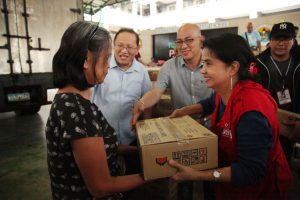 DSWD Secretary Virginia N. Orogo leads the distribution of DSWD family food packs to evacuees staying at H. Bautista Elementary School Evacuation Center in Marikina City. Also in the photo are Marikina City Mayor Marcelino Teodoro and District 1 Councilor Jojo Banzon. 