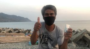 Even with his face mask on, Dominador is visibly happy as he gestures a thumbs up after receiving his emergency subsidy under the Social Amelioration Program.