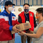 DSWD Secretary Rolando Bautista, together with DSWD-Field Office National Capital Region (NCR) Director Vic Tomas, hands over a Family Food Pack to an evacuee during a relief distribution in the region earlier today.
