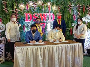 Department of Social Welfare and Development (DSWD) Secretary Rolando Joselito D. Bautista (seated left) and Butuan City Mayor Ronnie Vicente Lagnada sign the Memorandum of Agreement for the establishment of the Mindanao Disaster Resource Center. Also in the photo to witness the MOA signing are DSWD Undersecretary Luzviminda Ilagan (standing 2nd from right) and DSWD CARAGA Regional Director Ramel Jamen (standing second from left).