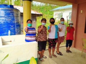 Community volunteers give a thumbs-up during the turnover of handwashing facilities.