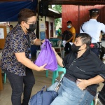 A social worker of the Department of Social Welfare and Development (DSWD) distributes a gift pack to a person with disability client at the DSWD Central Office.