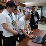 Department of Social Welfare and Development (DSWD) Secretary Rex Gatchalian observes the features of the newly-launched Finance and Management Service-For Your Information resource site as Director Wayne Belizar provides a walkthrough of the site during the project launch on Tuesday, February 14, 2023.
