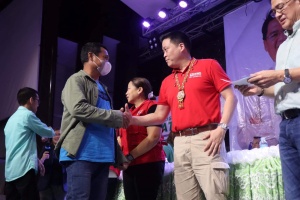 Department of Social Welfare and Development (DSWD) Secretary Rex Gatchalian greets a beneficiary who received financial assistance, under the Assistance to Individuals in Crisis Situation (AICS) program, during a payout activity in Butuan City on Saturday, March 18, 2023.